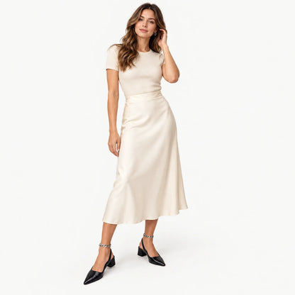 Model in black croc-embossed slingbacks with an ankle chain, styled with a cream satin midi skirt 1
