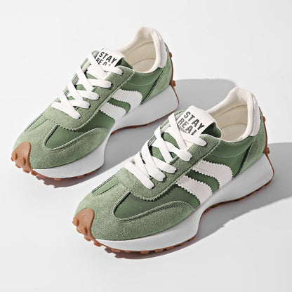 Pair of green suede and nylon trainers with white side stripes, white laces and gum soles, seen from above 1
