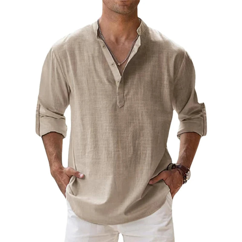 Man wearing the Henley shirt in beige with sleeves rolled up and hands in the pockets of white trousers. 1