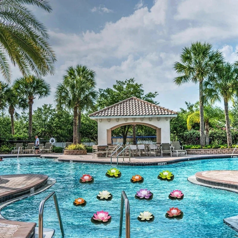 Pastel lotus lights scattered across a bright blue daytime swimming pool surrounded by palm trees 8