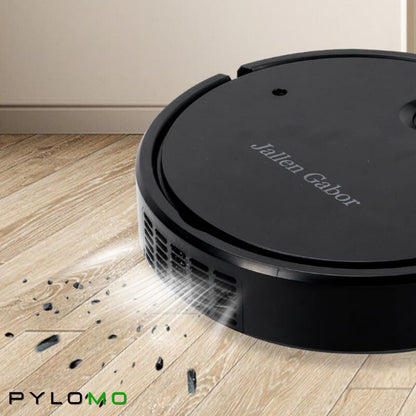 Close-up of the black robot cleaner's side air vents as it sucks up small debris from a wooden floor. 5