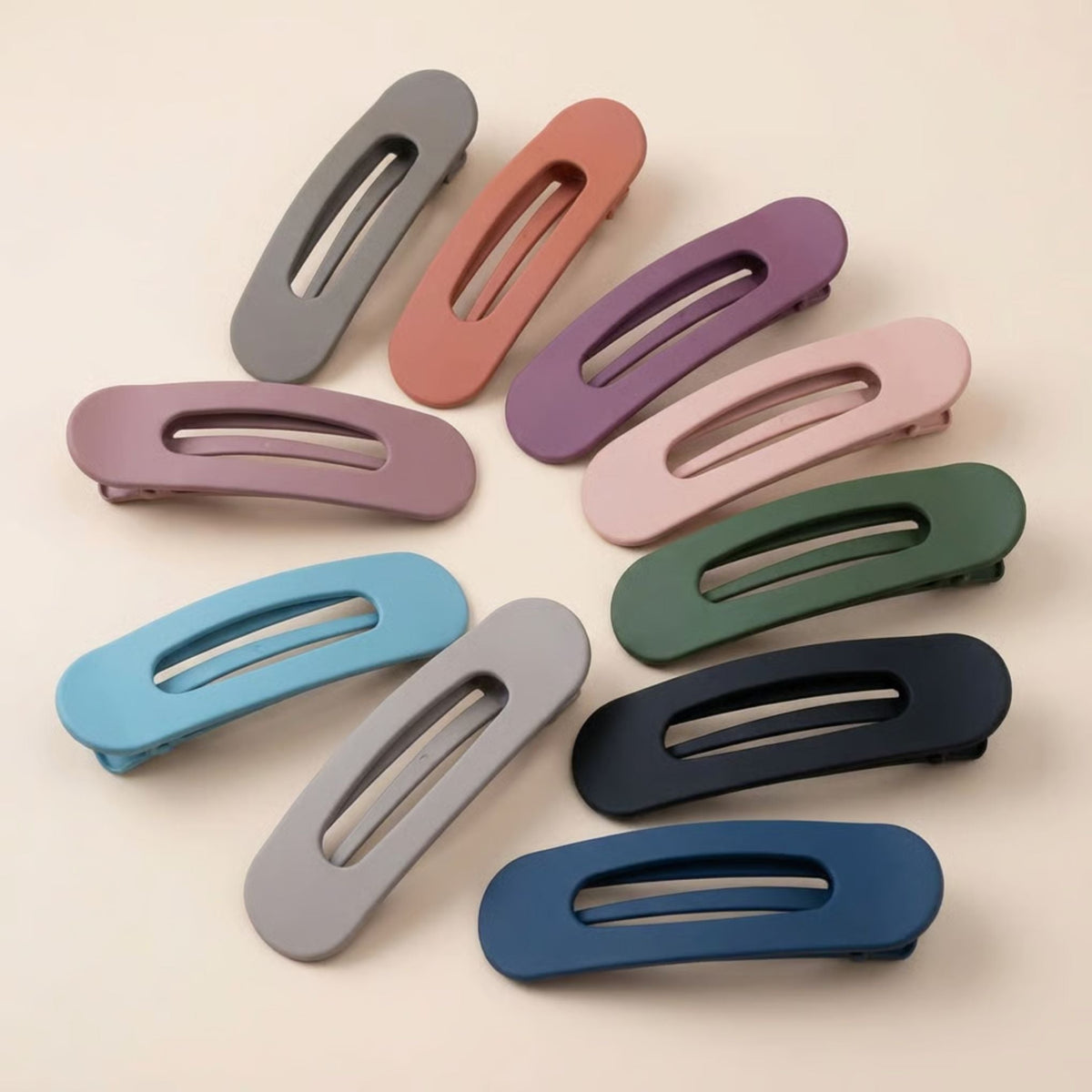 Ten matte slim flat hair clips in assorted muted colours, fanned out in a circle 1