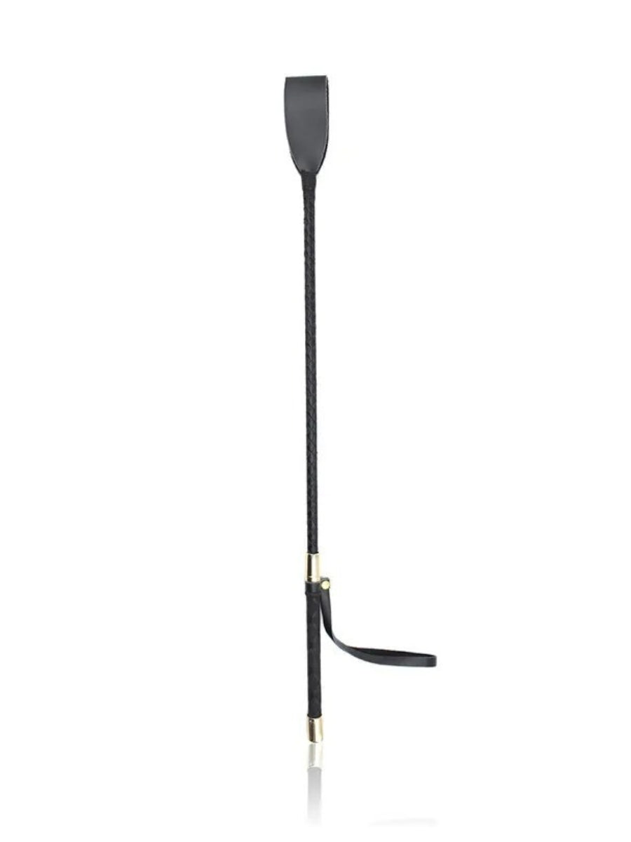 Full-length view of the black crop standing upright, showing the flat tip, braided shaft, gold-toned collars and dangling wrist strap. 4