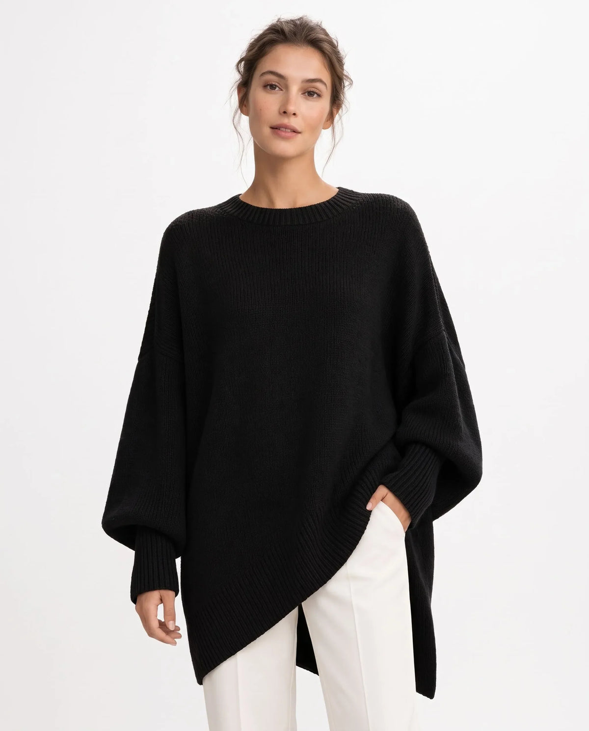 Model in black oversized knitted jumper with ribbed trims, one hand in the pocket of white trousers 1