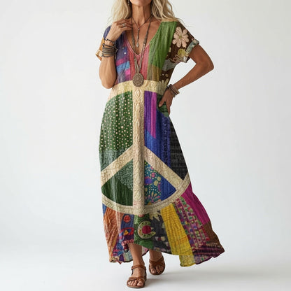 Model wearing a short-sleeved dress in multicoloured patchwork panels with a large cream peace-sign motif across the front, styled with layered bracelets and sa 2