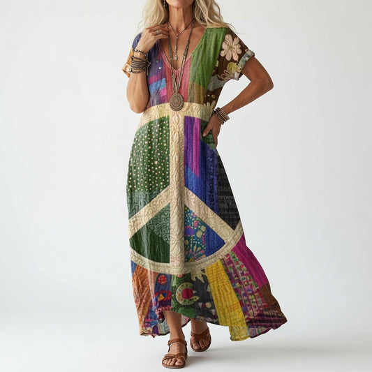 Model wearing a short-sleeved dress in multicoloured patchwork panels with a large cream peace-sign motif across the front, styled with layered bracelets and sa 2