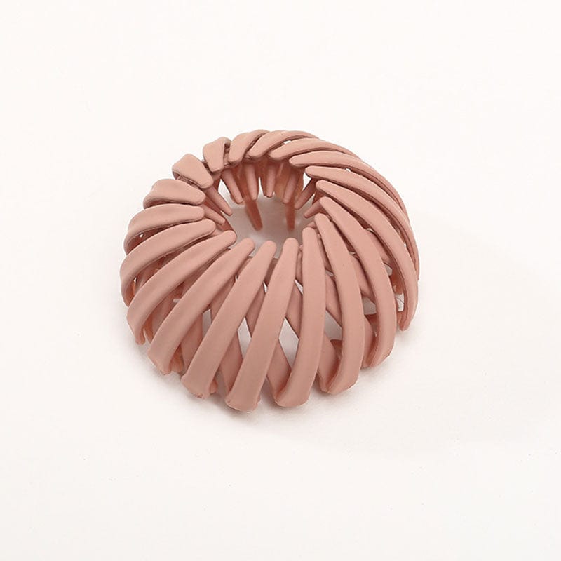 Single matte terracotta pink spiral clip with curved overlapping slats, photographed against a plain white background. 7