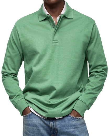 Front view of the polo in green on a model, showing the buttoned collar and ribbed cuffs over a striped shirt. 7