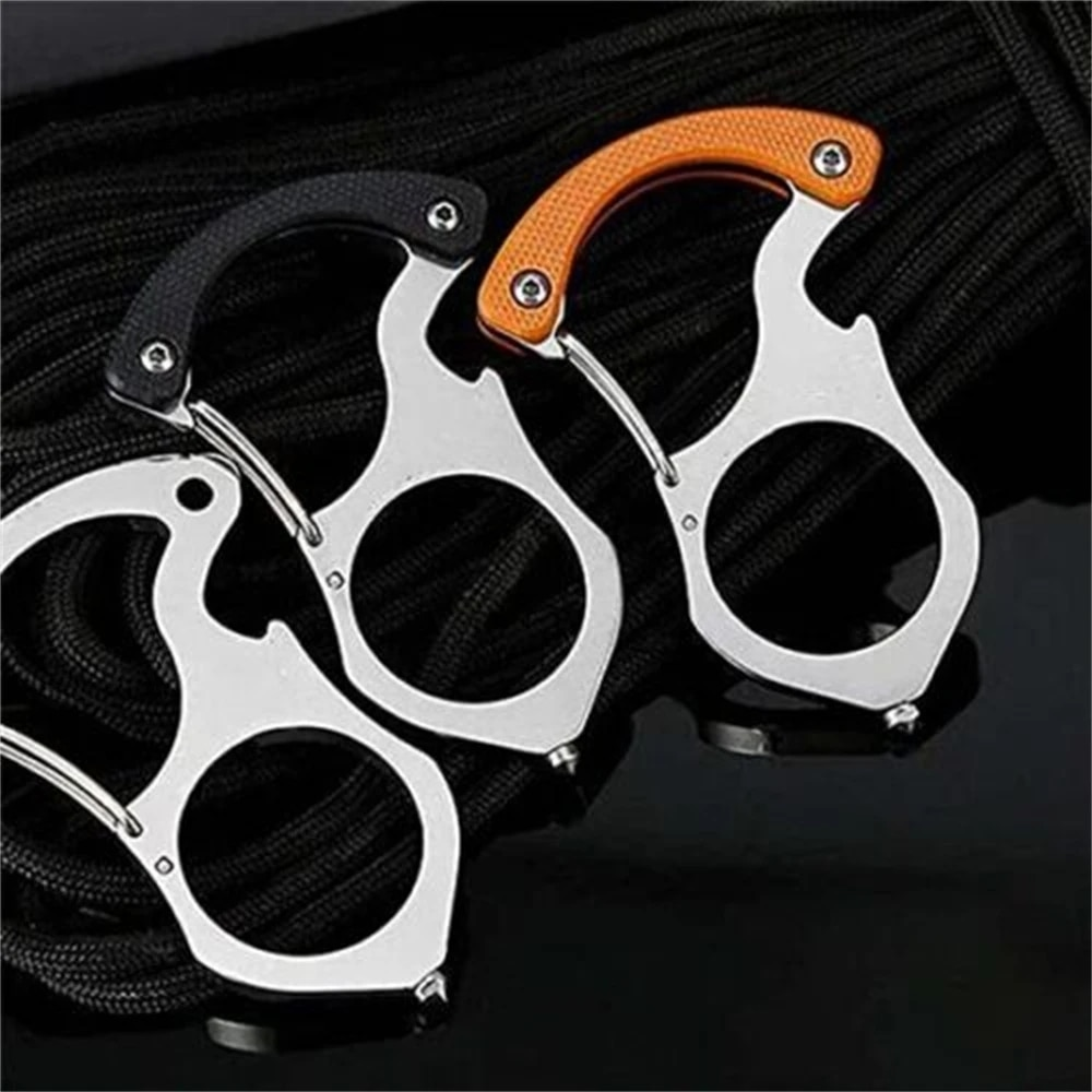 Three steel carabiner keyrings, two with black or orange handle grips, laid on coiled black cord against a dark background. 3
