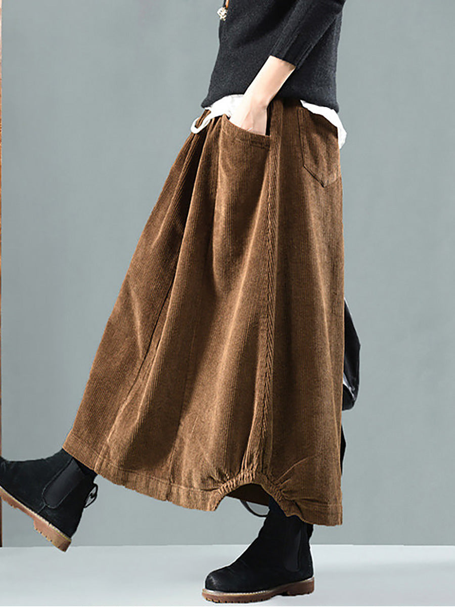 Brown version of the corduroy skirt in side view, with hand in pocket and gathered hem 3