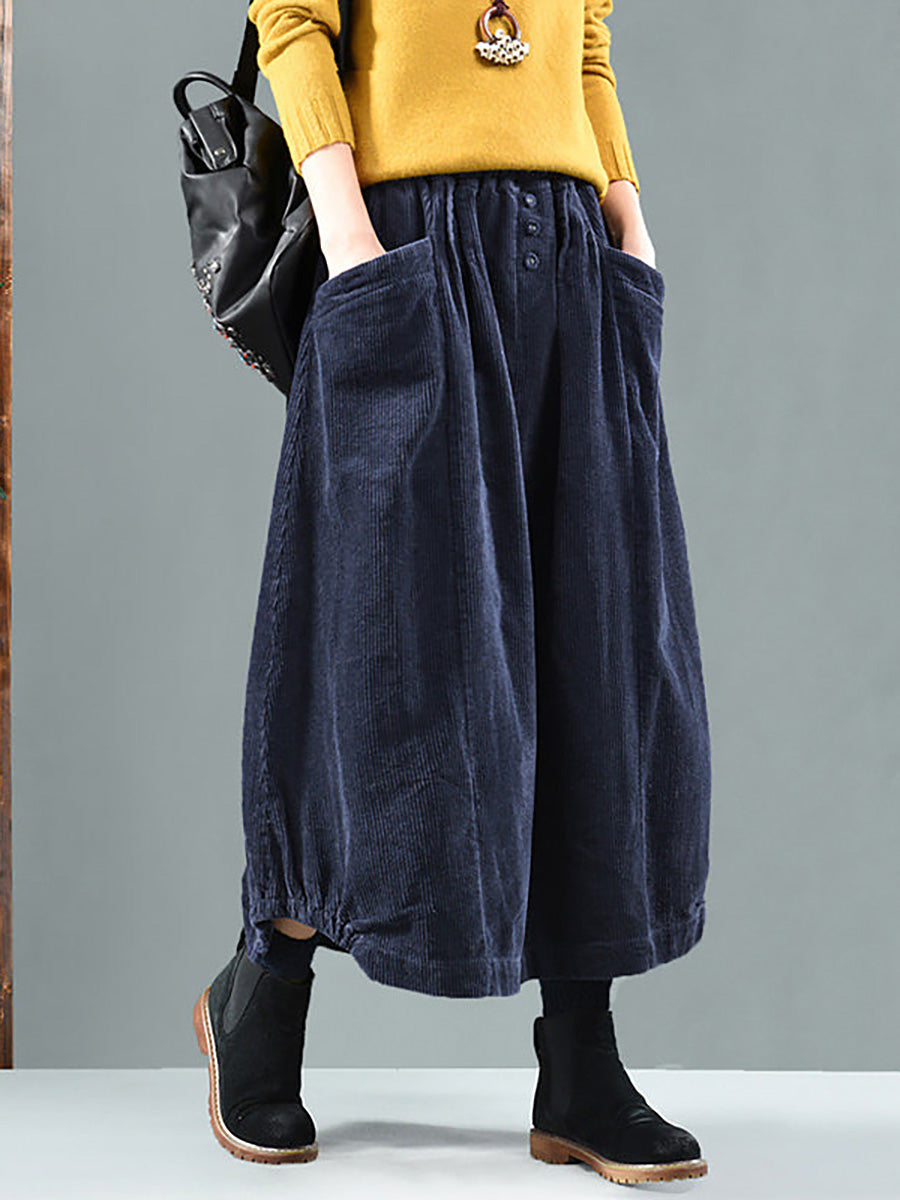 Navy corduroy skirt worn with a mustard jumper, hands in the large front pockets 4