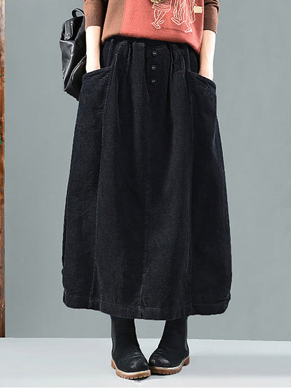 Black corduroy skirt on a model, front view showing three buttons and big patch pockets 5