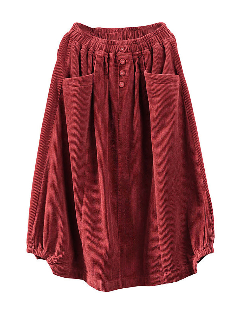 Red corduroy skirt laid flat, showing the elastic waistband, three buttons and two large pockets 6