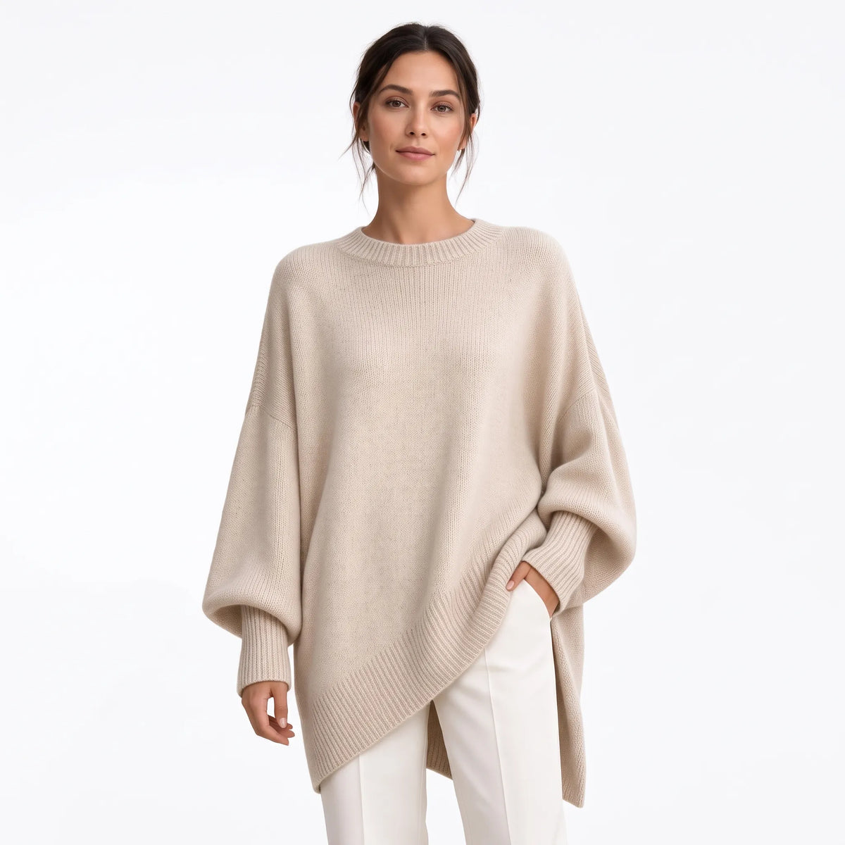 Studio shot of the cream jumper with ribbed trims, one hand in a pocket of white trousers 20