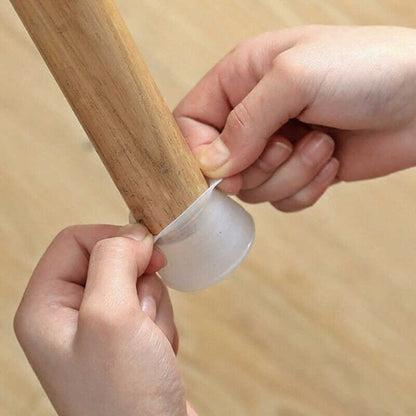 Two hands stretching a translucent silicone cap over the bottom of a wooden furniture leg, showing how it is fitted. 1