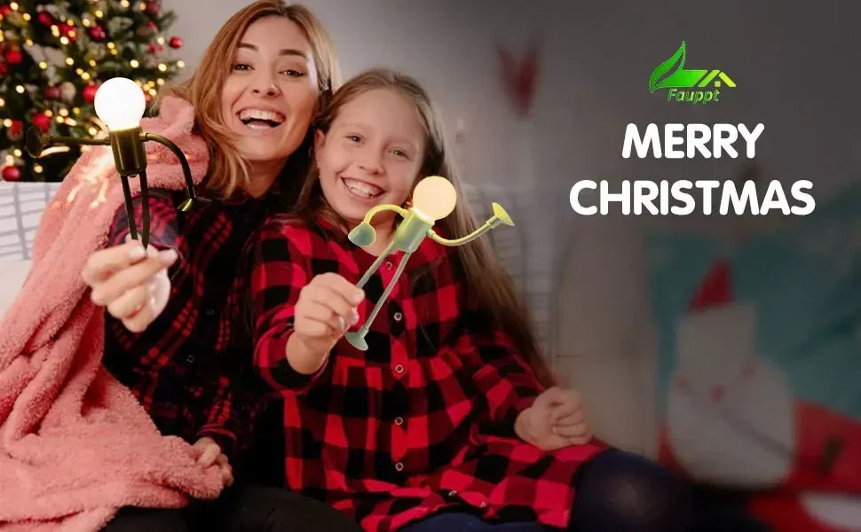 Mother and daughter in red checked shirts hold glowing figure lights beside a Christmas tree 21