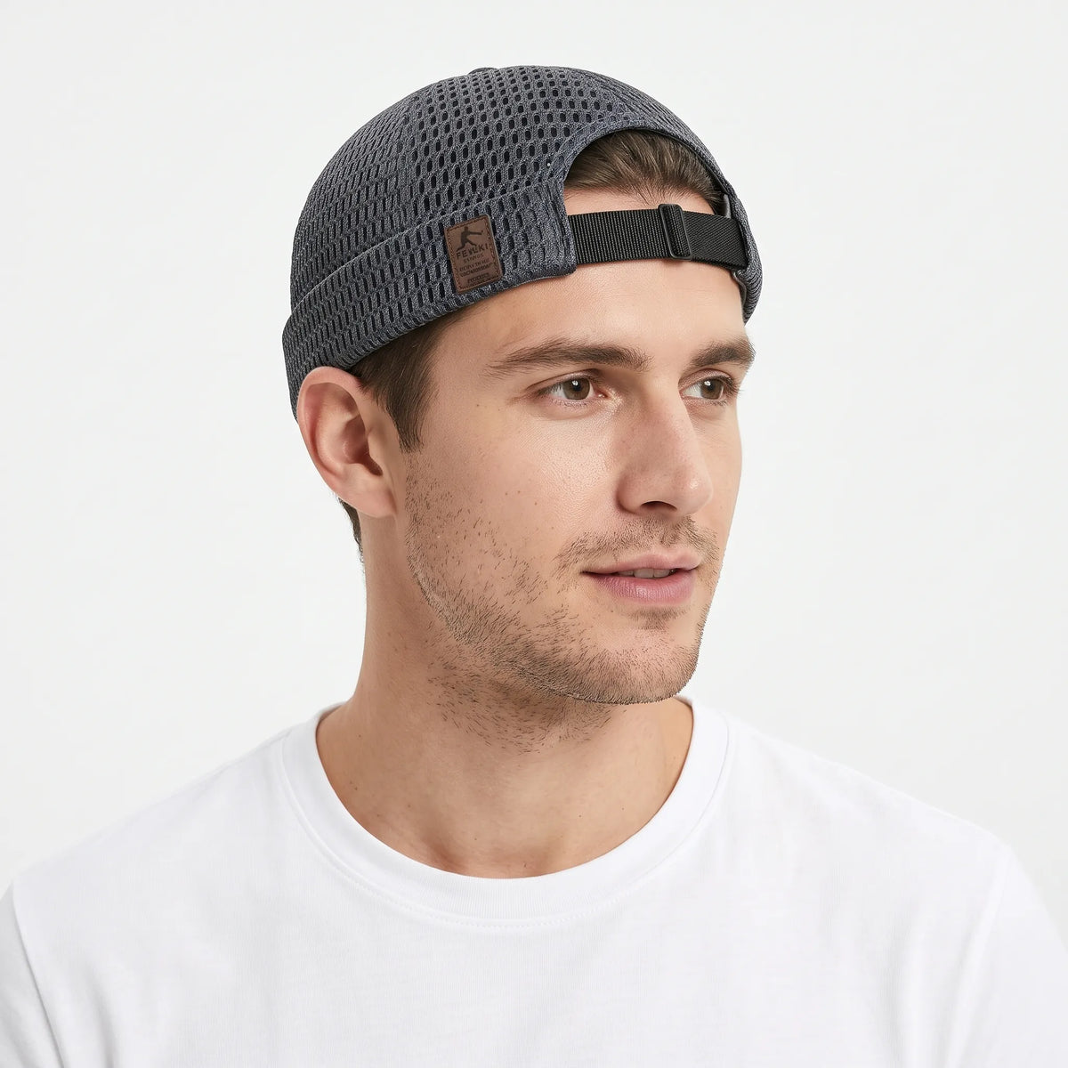 Man in a white t-shirt wearing the dark grey open weave cap, rear strap showing 21