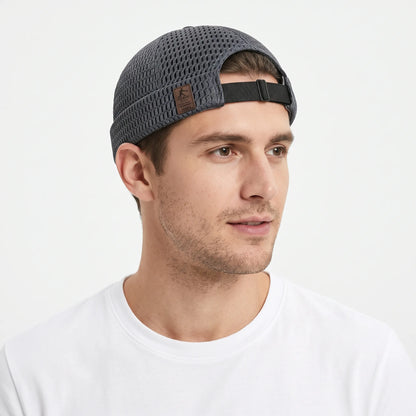 Man in a white t-shirt wearing the dark grey open weave cap, rear strap showing 21