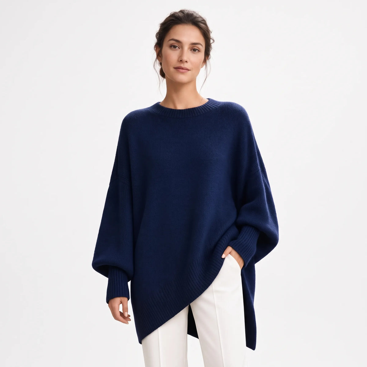 Model wears the same oversized jumper in navy, hand in pocket, with white trousers 22
