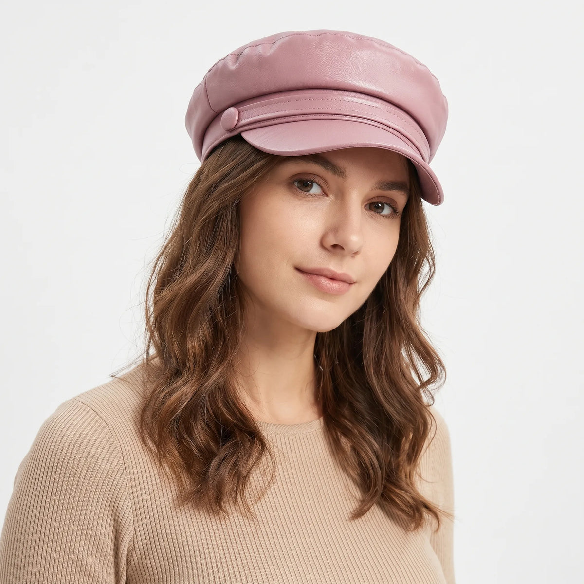 Woman wearing the baker boy hat in dusky pink leather-look with button detail, with a ribbed beige top 22