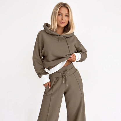 Model wearing the tracksuit in brown with white ribbed hem and cuffs, hand in trouser pocket 23