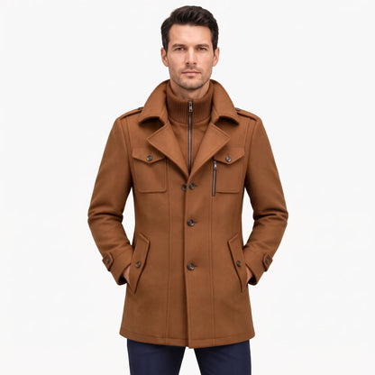 Man modelling the tan-brown overcoat from the front, ribbed inner collar zipped up beneath the lapels 23