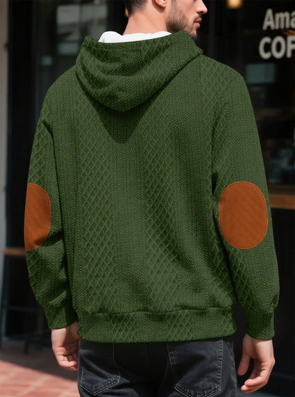 Back view of the olive green hoodie on a model, showing large tan elbow patches 23