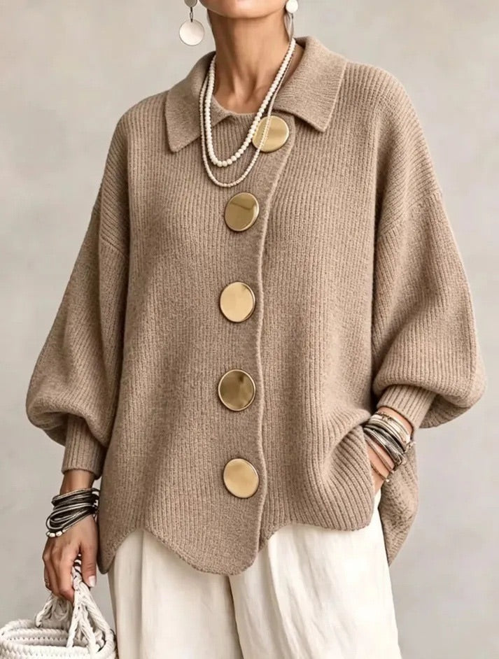 Camel-brown ribbed cardigan on a model, showing five gold buttons, pointed collar and wavy hem, with cream trousers. 7