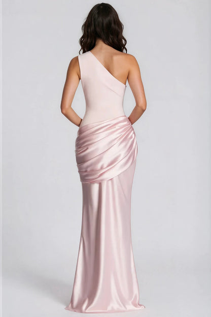Back view of the pale pink one-shoulder maxi dress, showing the diagonal neckline, fitted bodice and draped satin hip detail. 31