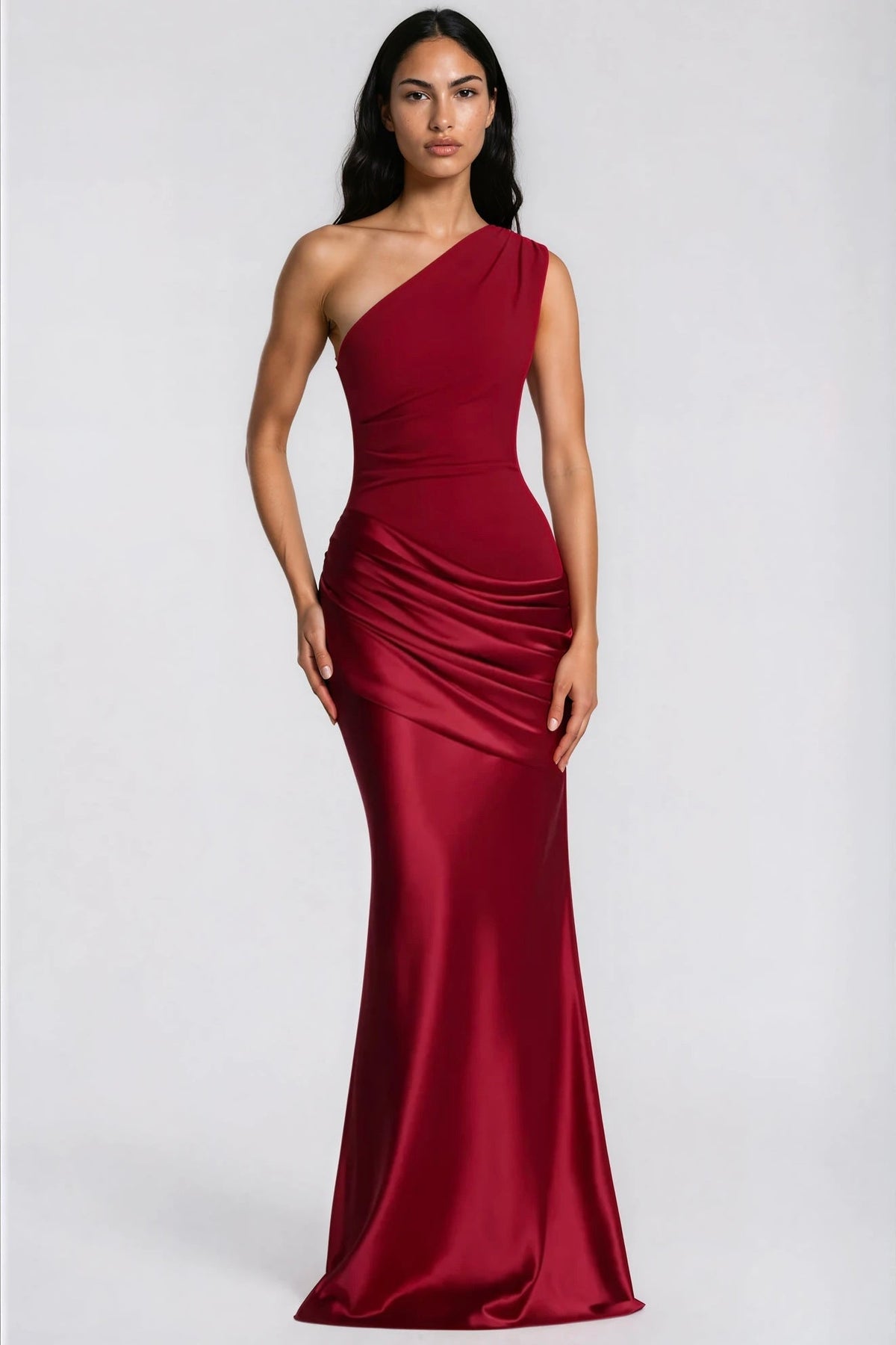 Front view of the deep red one-shoulder maxi dress on a model, with a ruched crepe bodice and draped satin waist. 34