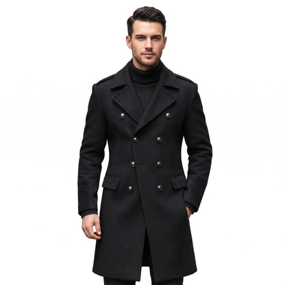 Man wearing the overcoat in black with metal buttons, notch lapels and flap pockets over a black roll-neck 24