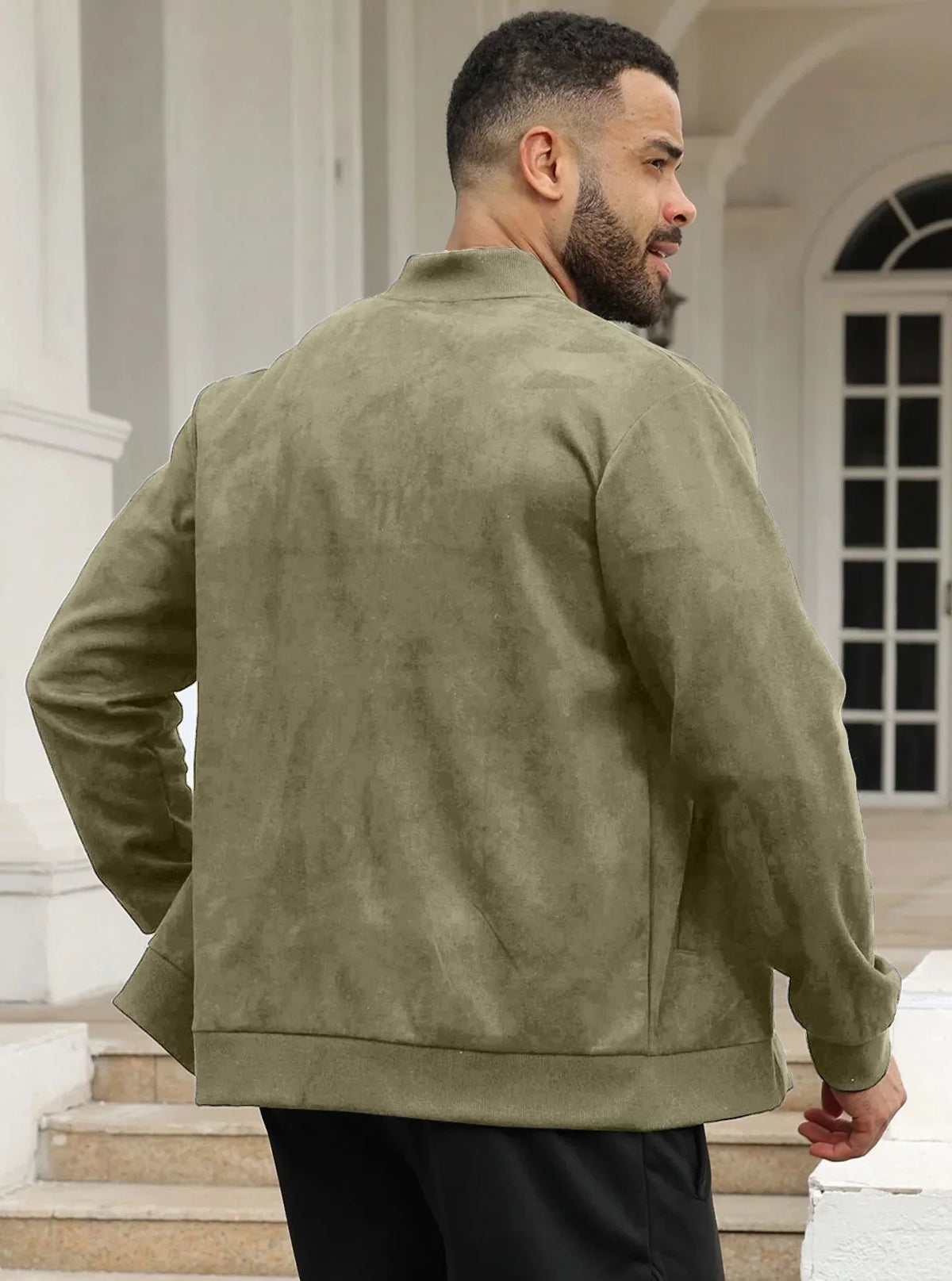 Man seen from behind in the olive green jacket, standing on steps by white columns 24