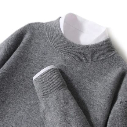 Close-up flat lay of the mid grey knitted jumper showing ribbed mock neck and cuff over a white shirt 25
