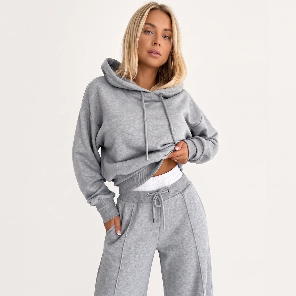 Model wearing the tracksuit in marl grey with matching drawstring hood, white layer showing at the waistband 26