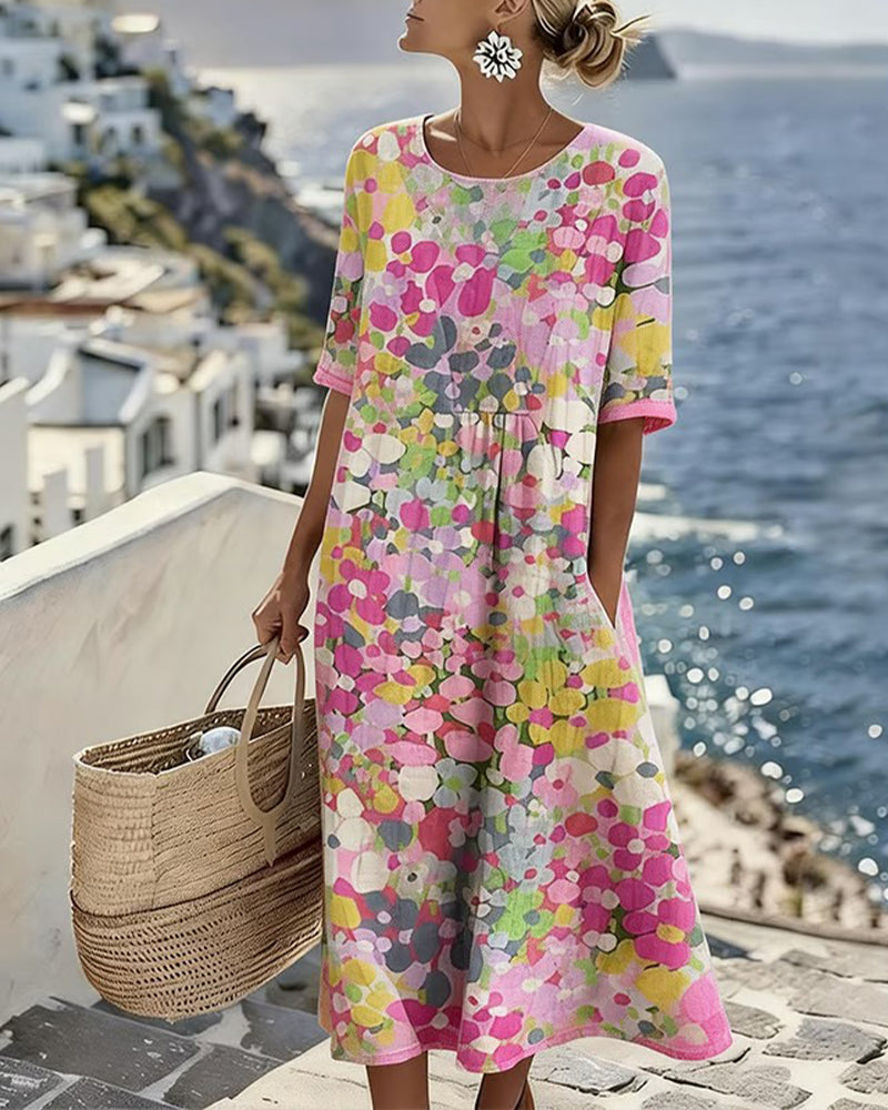 Model wearing the pink floral midi dress with pocket, holding a woven basket by the sea 1