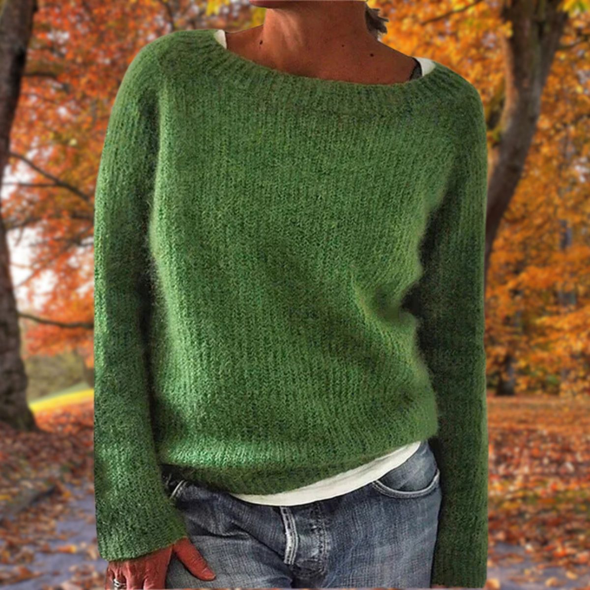 Model in the green version of the fluffy knit jumper, layered over a white top and jeans in an autumn setting. 5