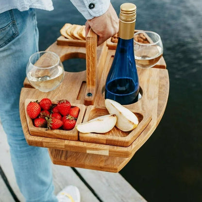 Person in jeans carries the loaded wooden table by its handle, with strawberries, pear slices, two glasses and a blue bottle 5