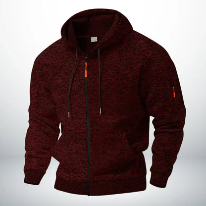 Front view of the zip-up hoodie in speckled dark burgundy, showing the drawstring hood, orange zip pull and zipped sleeve pocket. 2