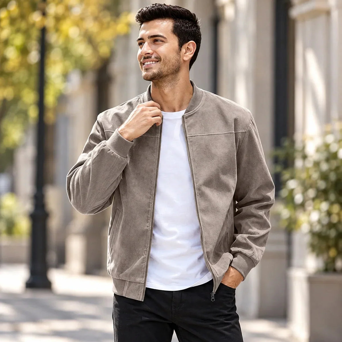 Smiling man outdoors wearing the taupe zip-up jacket with ribbed collar, one hand in his pocket 2