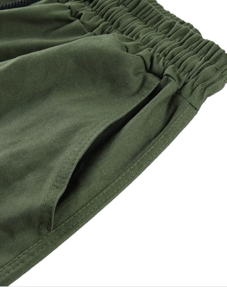Close-up of the olive green elasticated waistband and a stitched side pocket opening. 13