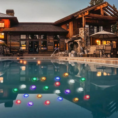 Many multicoloured glowing lotus lights floating on a swimming pool at dusk outside a timber house 7