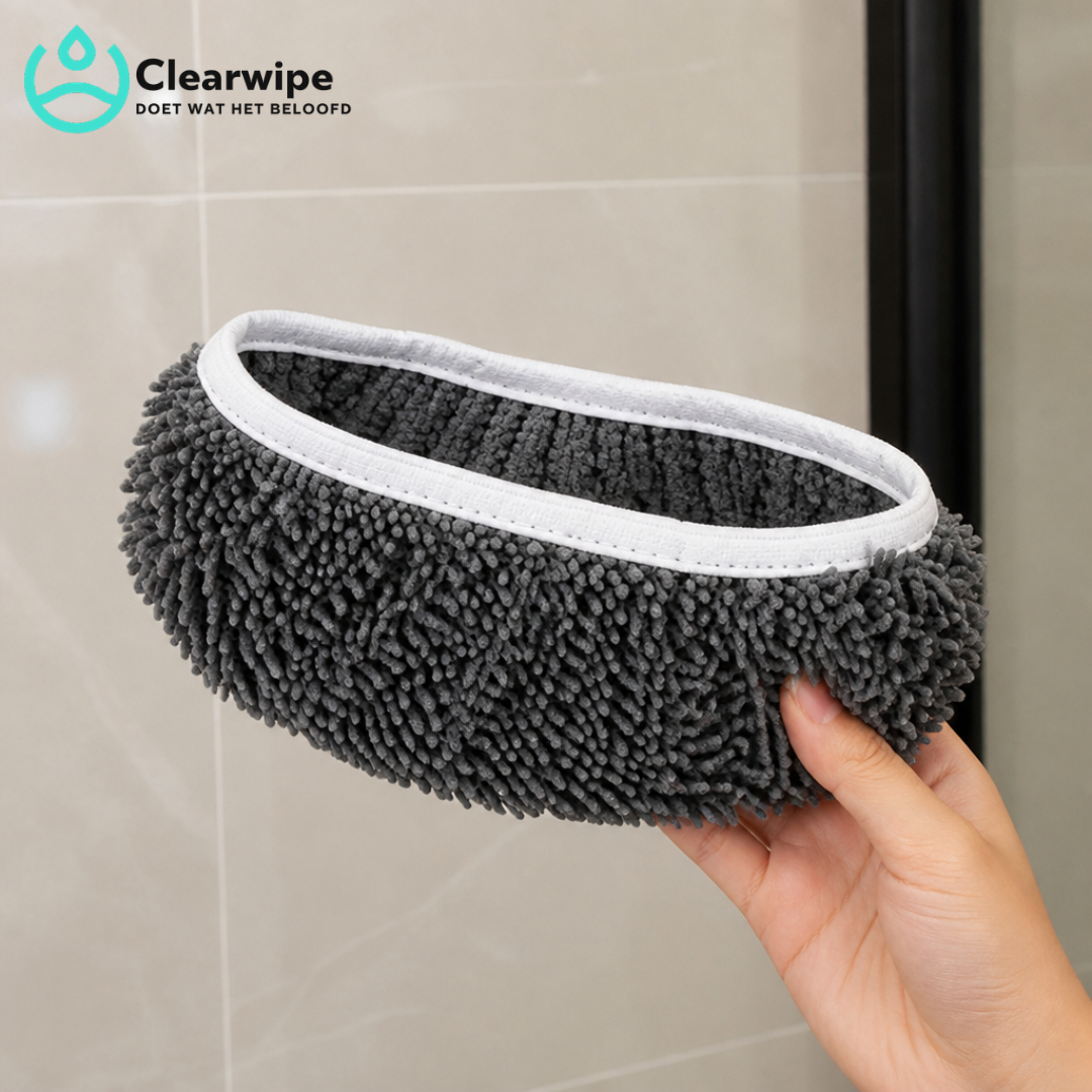 Hand holding a single grey chenille mop pad with a white stitched edge in front of tiled bathroom wall. 4