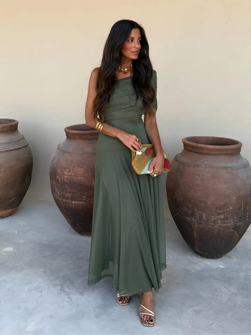 Full-length front view of the olive green one-shoulder mesh dress with a colourful clutch 10