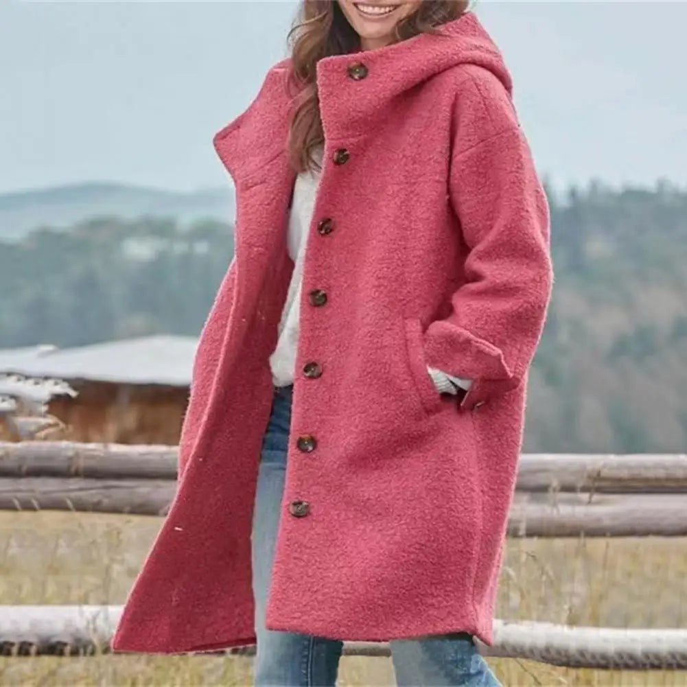Model in the red buttoned coat with the hood up, hand in pocket, standing by a wooden fence 2