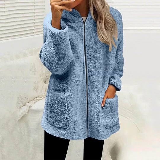 Model wearing the zipped fluffy fleece jacket in light blue with black leggings, hand in a pocket 3