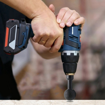 Cordless drill held in both hands with a black ball-shaped carving bit attached, just above a surface 9