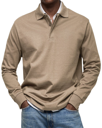 Model wearing the polo in tan beige, relaxed fit with hands in jeans pockets and a striped shirt underneath. 8