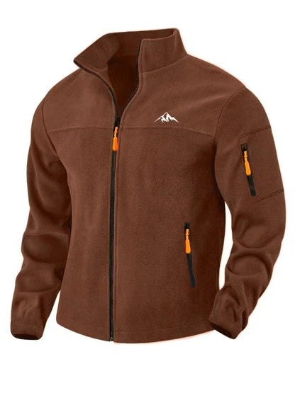 Front three-quarter view of the brown fleece jacket with stand collar, orange zip pulls, chest zip pocket and sleeve pocket. 1