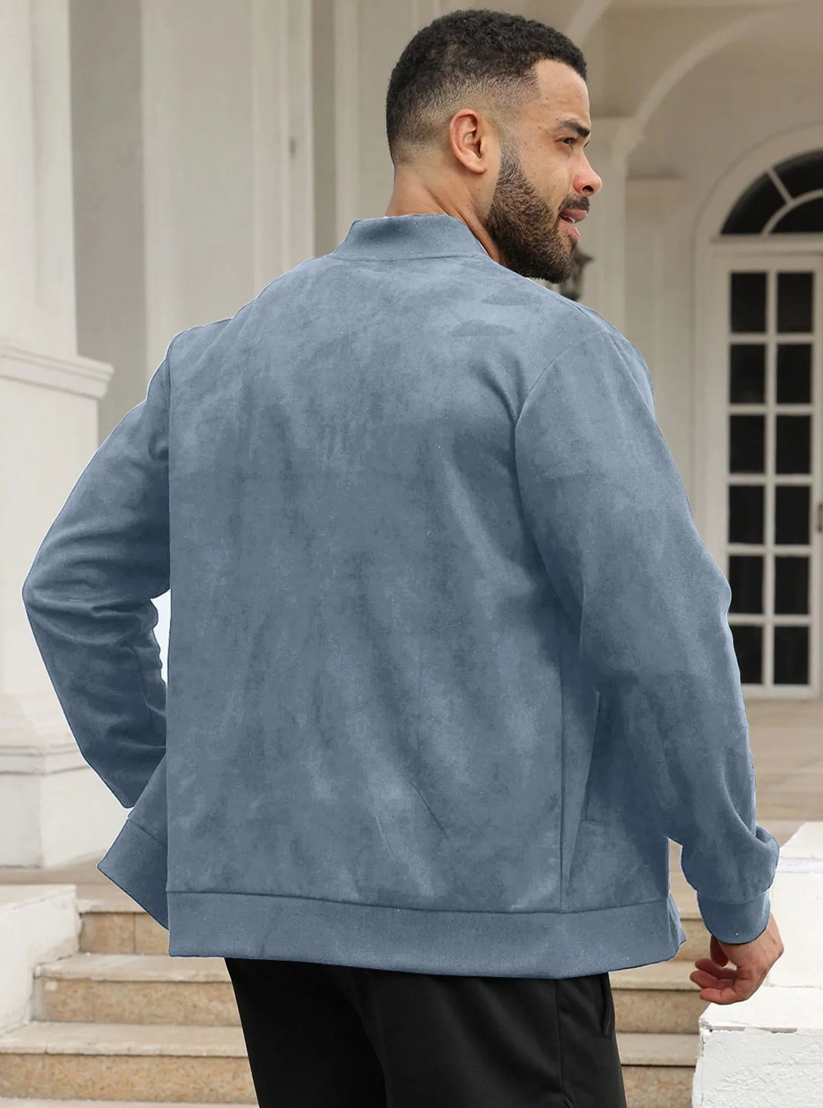 Man wearing the blue-grey zip-up jacket outdoors, front view, hand resting at his collar 31