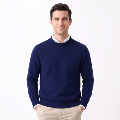 Man wearing the navy knitted jumper over a white collared shirt with beige trousers 32